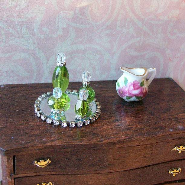 Dollhouse miniature green perfume bottles and vanity tray.